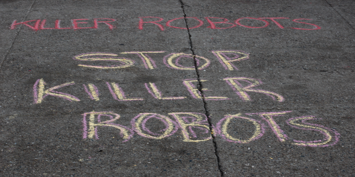 chalk on the sidewalk reading "STOP KILLER ROBOTS"