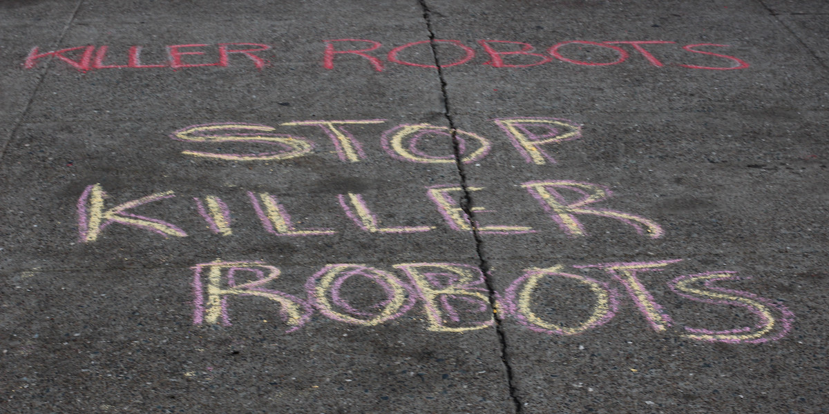 chalk on the sidewalk reading "STOP KILLER ROBOTS"