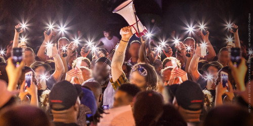 Protestors hold phones and bullhorns up